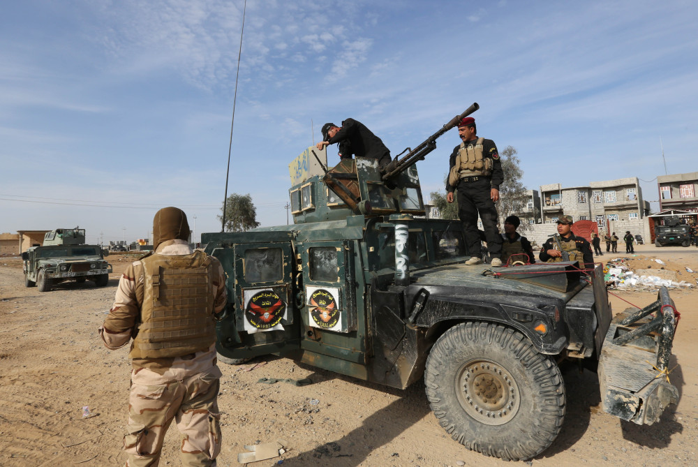 In this Monday, photo, Iraqi security forces deploy in a military operation to regain control of the villages around the town of Beiji, some 250 kilometers (155 miles) north of Baghdad, Iraq.