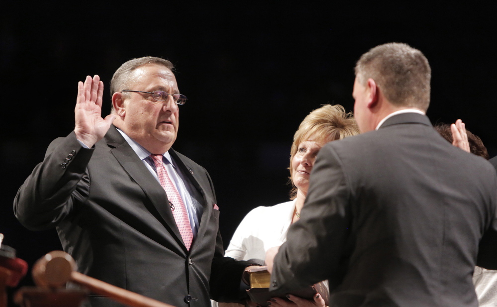 Maine Senate President Michael Thibodeau administers the oath of office to Gov. Paul LePage, who is joined by his wife, Ann. The governor said his decisive election victory translates into voter endorsement of his policies.