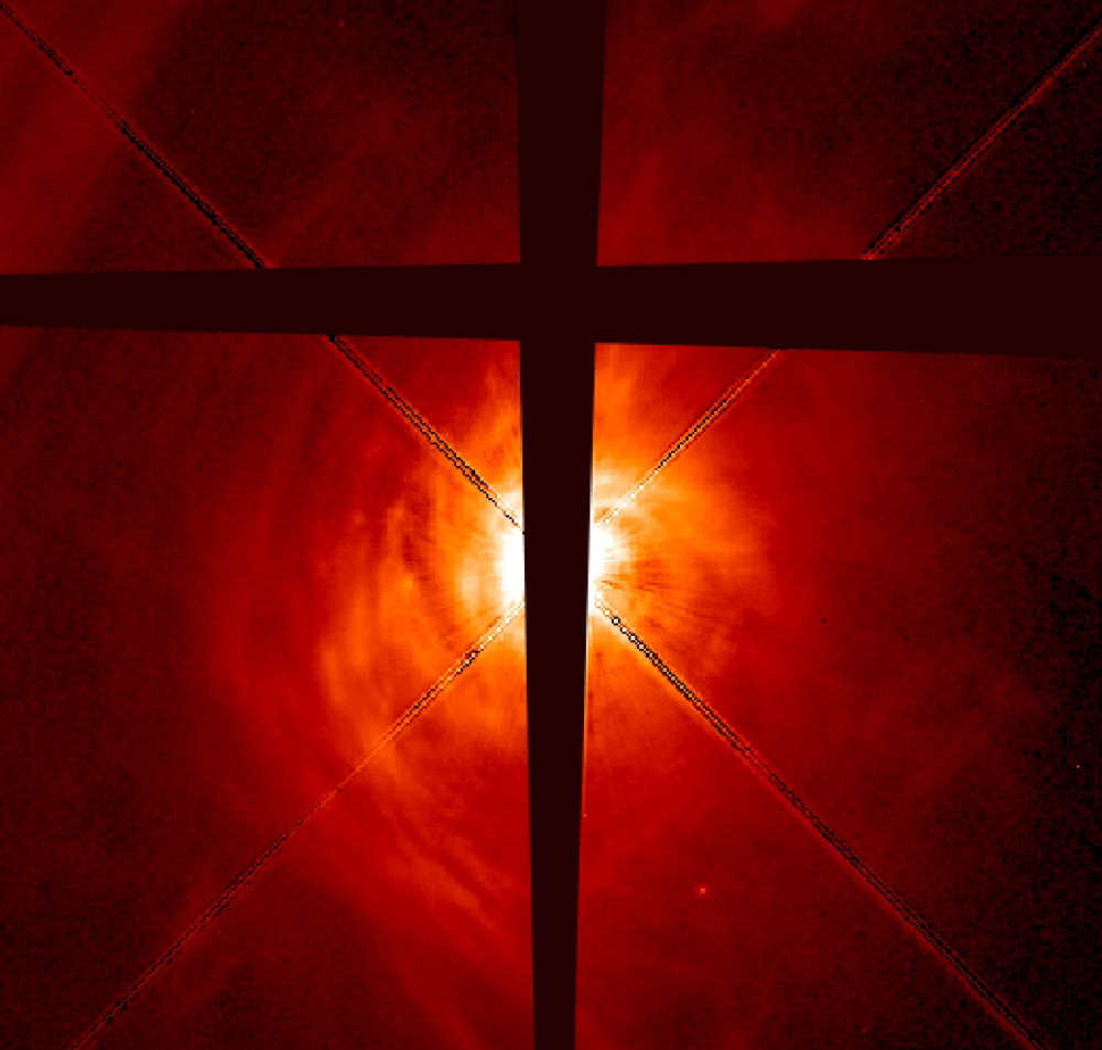 The developing star AB Aurigae has a swirling disk of dust and gas that includes clumps thought to be the beginnings of planet formation. The dark lines in the photo are made by an occulting bar on the telescope that cuts the glare from the star and makes the potentially planet-forming disk more visible. Some astronomers think that almost all stars in our galaxy have planets.