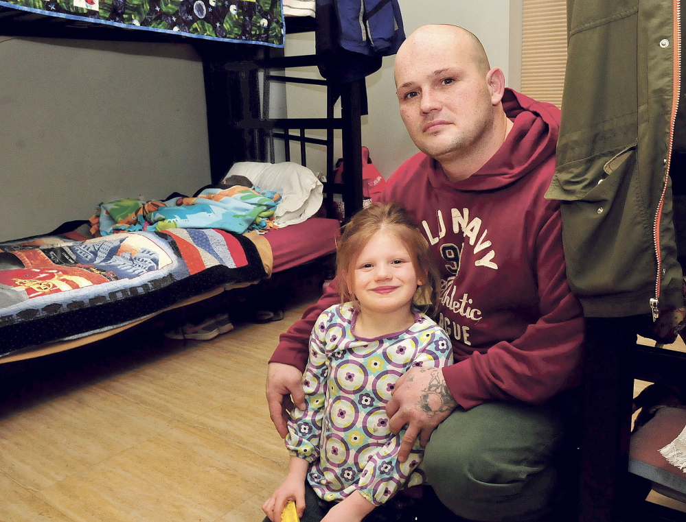 Richard Walsh and his children, Autumn and Aiden, sleeping in bed, in the room they share at the Mid-Maine Homeless Shelter in Waterville on Wednesday.