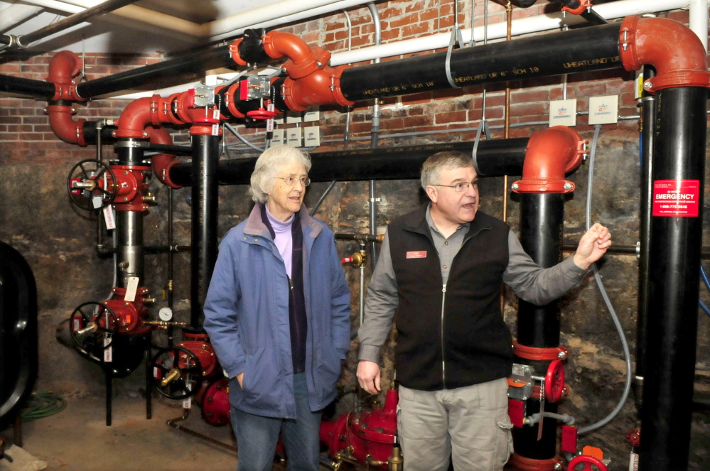 Skowhegan Free Public Library trustee Corrilla Hastings and Director Dale Jandreau speak about the renovation project in the 125-year-old building. Behind them is new sprinkler system equipment.