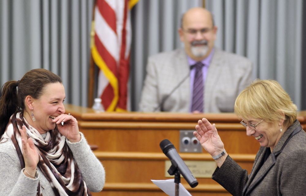 Deborah Towle, left, laughs Thursday with Attorney General Janet Mills while being sworn into the Augusta School Board at City Center in Augusta.