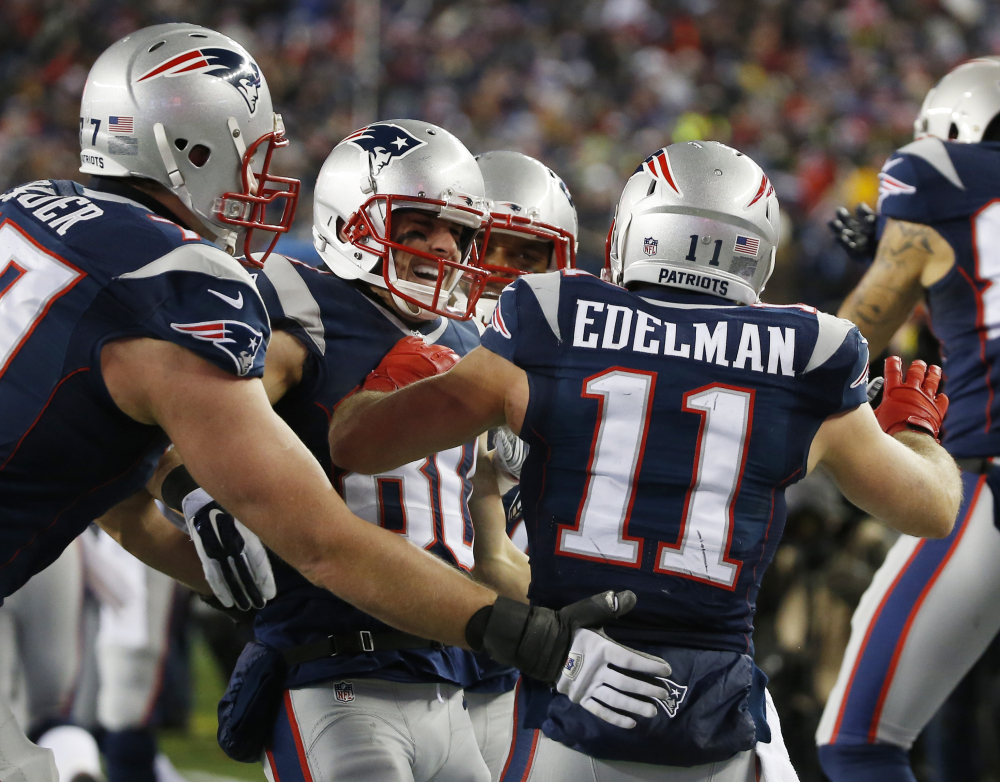 New England Patriots wide receiver Danny Amendola, center, celebrates his 51-yard touchdown pass from Julian Edelman, 11, in the second half Sunday against the Baltimore Ravens in Foxborough, Mass. The Patriots won 35-31.
