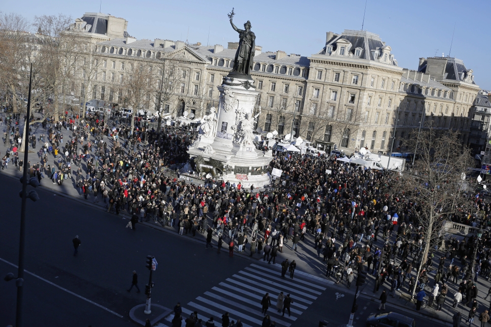 People start gathering at Republique square before the demonstration, in Paris on Sunday. A rally of defiance and sorrow, protected by an unparalleled level of security, on Sunday will honor the 17 victims of three days of bloodshed in Paris that left France on alert for more violence.