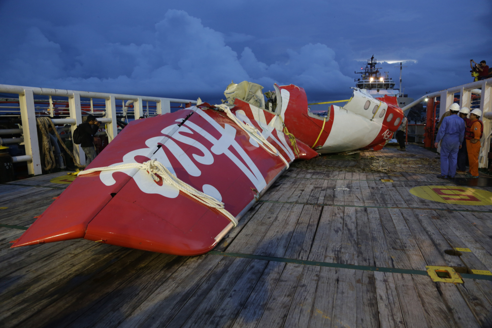 Parts of AirAsia Flight 8501 is seen on the deck of rescue ship Crest Onyx at Kumai port in Pangkalan Bun, Indonesia, on Sunday. A day after the tail of the crashed AirAsia plane was fished out of the Java Sea, the search for the missing black boxes intensified Sunday with more pings heard.