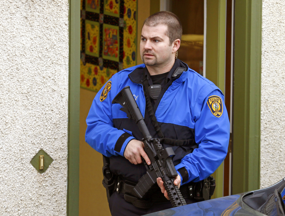 A police officers stands outside an office where two men were shot in Moscow, Idaho, on Saturday. Police say a gunman killed three people and critically wounded another during a spree at three locations in Moscow, Idaho.