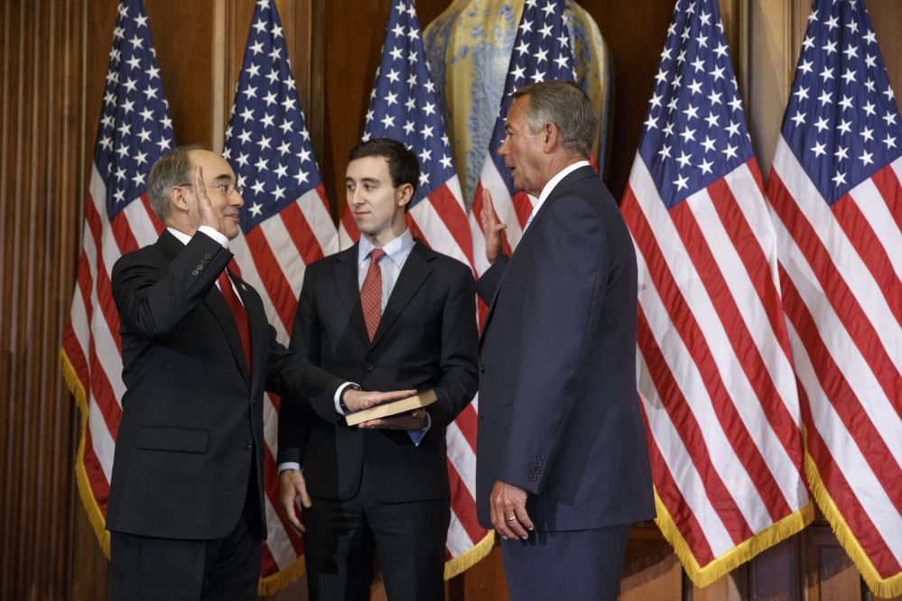 U.S. Rep. Bruce Poliquin, R-Maine, left, with his son, Sam, center, stands with House Speaker John Boehner, of Ohio, for a ceremonial swearing-in and photo-op during the opening session of the 114th Congress on Tuesday on Capitol Hill in Washington.