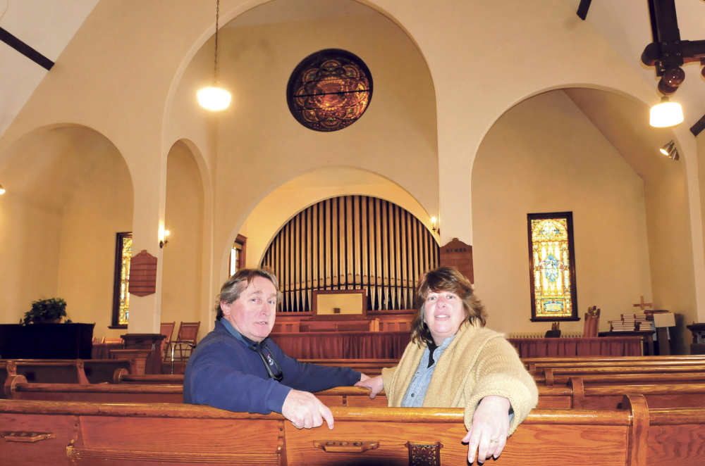 Tom and Stacy O’Brien sit in one of the pews before the front altar of the Madison Congregational Church on Monday. The O’Briens have acquired the historic downtown landmark and plan to turn it into a wedding and event venue called the Somerset Abbey.