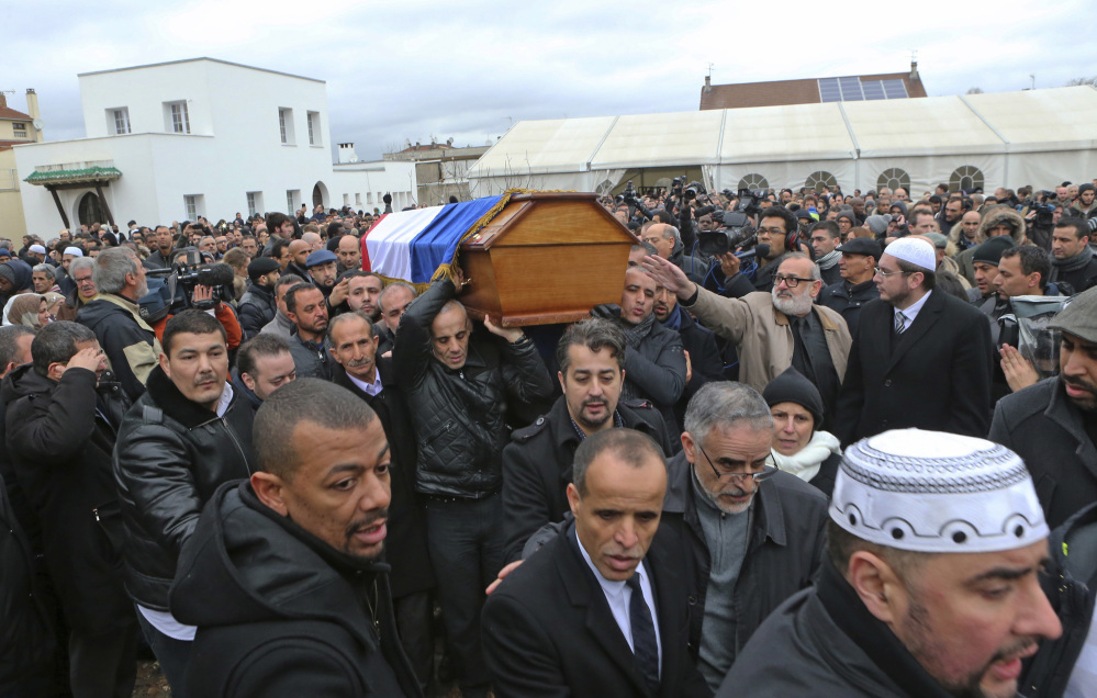 People carry the coffin of slain police officer Ahmed Merabet after a funeral service at the  Bobigny mosque, east of Paris, France, Tuesday.