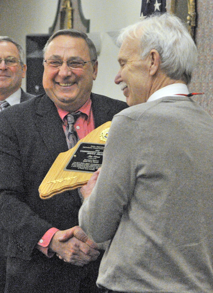 Gov. Paul LePage presents an award to Jon Olson, executive secretary of the Maine Farm Bureau Association, on Tuesday at the Augusta Civic Center during the Maine Agricultural Trades Show.