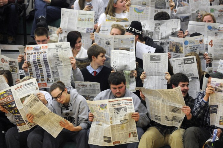 Winthrop High School fans read the newspaper while waiting for Boothbay to complete a foul shot during a Mountain Valley Conference game in January 2015 in Winthrop.