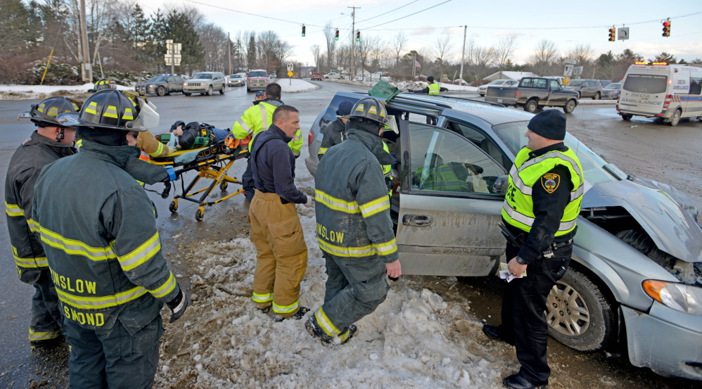 Delta Ambulance paramedics and Winslow firefighters remove a woman from a minivan in which she was a passenger when the van was involved in a three-car accident Friday at the intersection of Carter Memorial Drive and Augusta Road in Winslow.