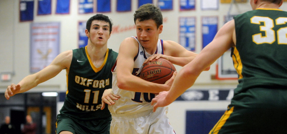 Staff photo by Michael G. Seamans 
 Messalonskee's Nathan Violette, middle, drives past Oxford Hills defenders Tyus Ripley, left and Andrew Fleming during a Kennebec Valley Athletic Conference Class A game Friday night.