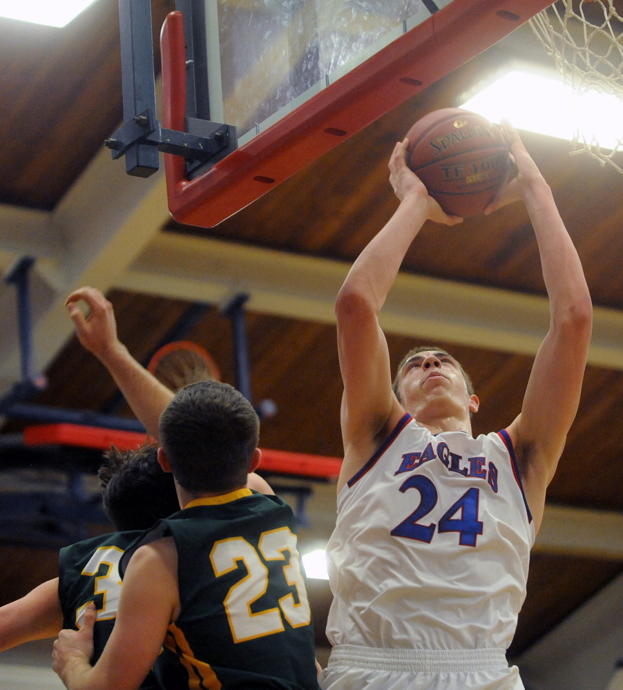 Staff photo by Michael G. Seamans 
 Messalonskee High School's Nick Mayo (24) puts up a shot over Oxford Hills' Cole Everett during a Kennebec Valley Athletic Conference Class A game Friday night.