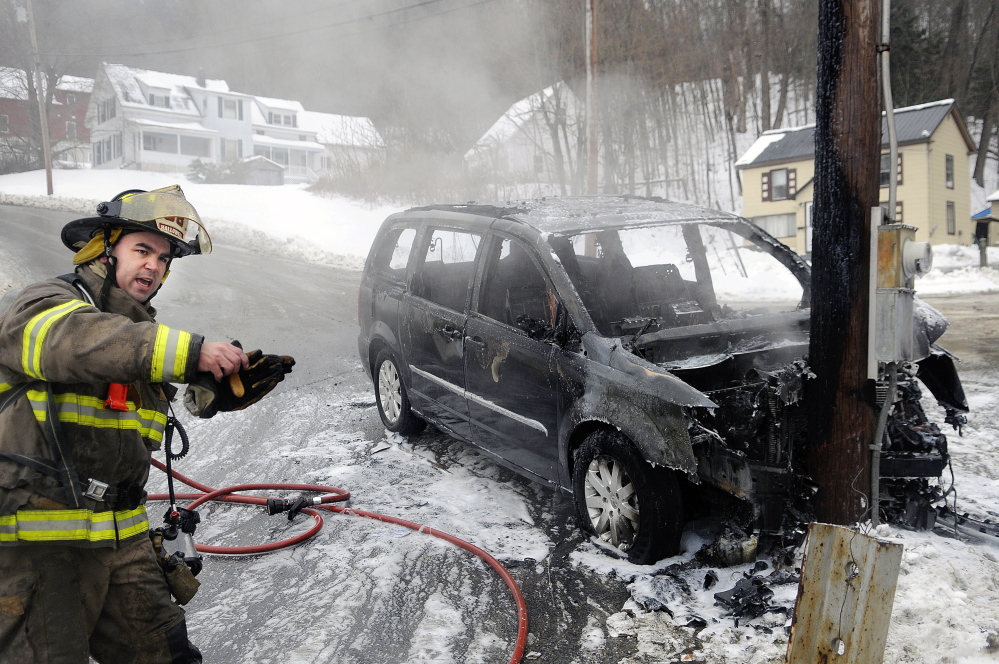 Hallowell firefighter Roy Girard directs fellow volunteers Sunday while extinguishing a van that burned after sliding into a utility pole on Greenville Street in Hallowell. Multiple accidents were reported across central Maine as a light drizzle fell as temperatures remained in the low 30s. The operator of the van had departed by the time firefighters arrived, according to Captain Richard Clark.