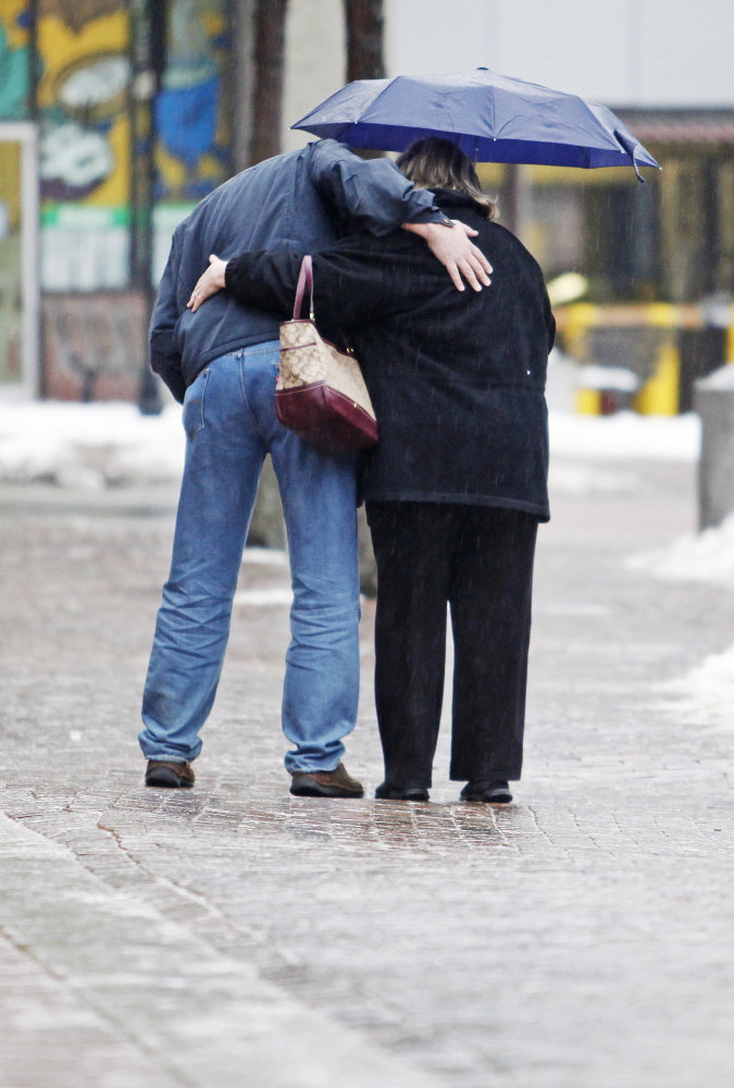 Jill Brady/Staff Photographer
A couple holds on while making their way gingerly across icy brick sidewalks along Free Street in Portland as a cold rain falls Sunday.
