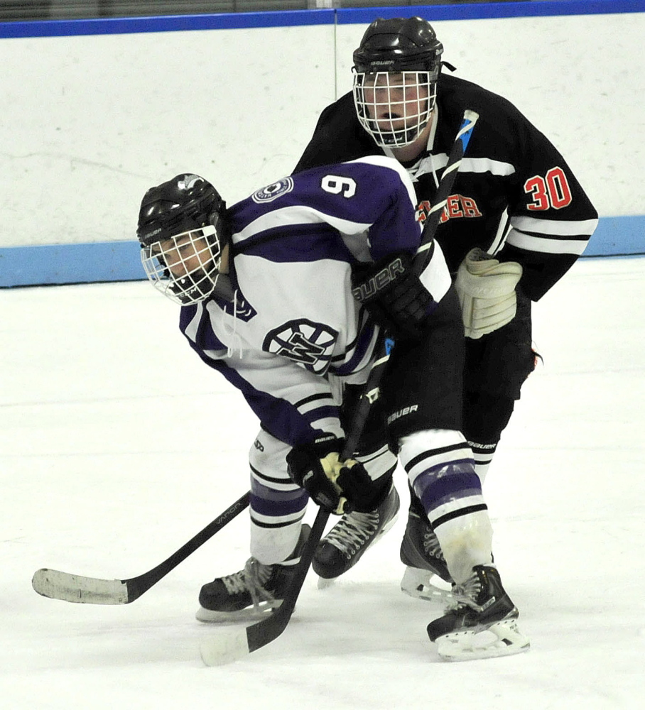 Waterville forward Dalton Henderson is pressured by Brewer’s Cameron Green during an Eastern B game Monday afternoon in Waterville. Henderson finished with a hat trick in a 6-3 victory.