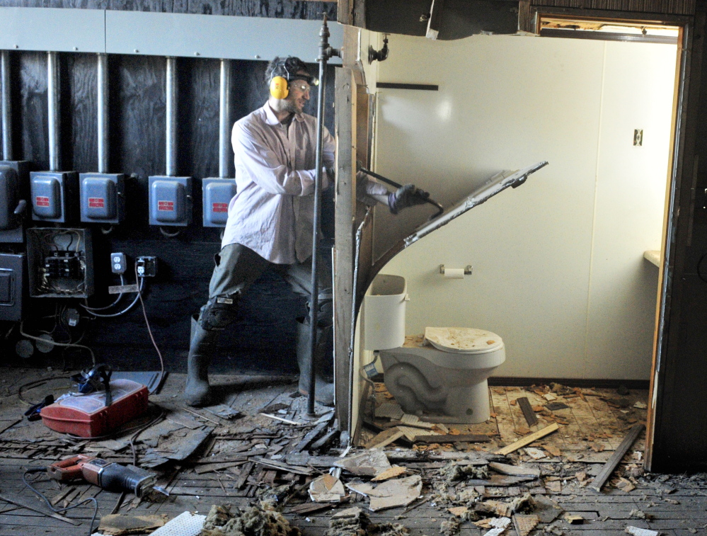 Alex Rosenberg performs demolition work Tuesday in the space that will become the Gardiner Food Co-op & Cafe on Water Street in downtown Gardiner.