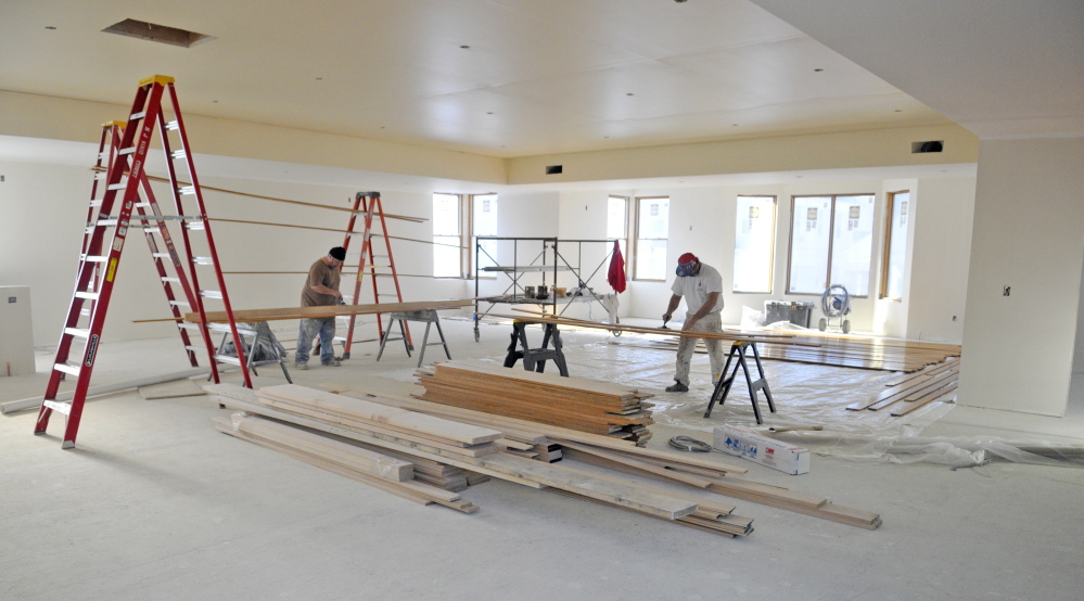 Ray Gagnon, left, and Larry Liston finish oak boards Wednesday at Charles M. Bailey Library in Winthrop. The men, who work for Ace Corp., said that the wood will be used in finishing details in the new library.