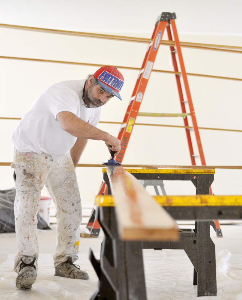 CAP.cutline_standalone:Larry Liston finishes oak boards Wednesday at Charles M. Bailey Public Library in Winthrop. The painter, who works for Ace Corp., said that the wood will be used in finishing details in the new library.