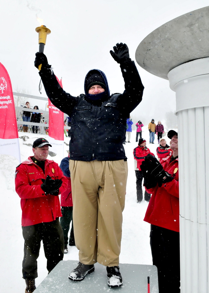 Torch bearer Jerry Bourget gets a standing ovation after lighting the torch to kickoff last year’s Special Olympics Maine Winter Games.