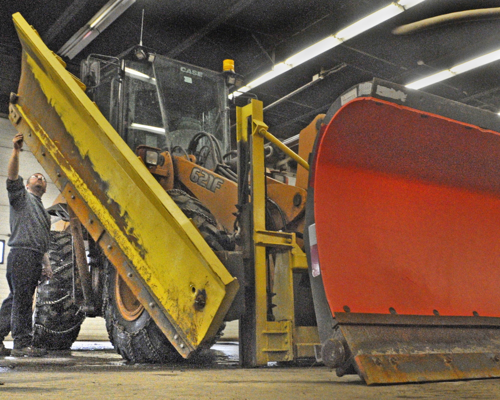 Mechanic Nate McLaughlin inspects the plow blades on a front end loader on Friday at the The John Charest Public Works Facility in Augusta.