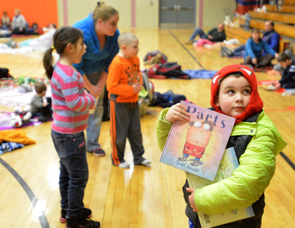 Benjamin Thomas, 5, clutches his favorite books as he arrives at the Books and Blankets event at Winslow Elementary School this week.
