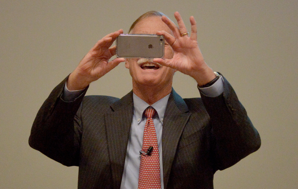 Sen. Angus King, takes a photo of the audience to post to Instagram before speaking at the University of Maine at Farmington on Friday.