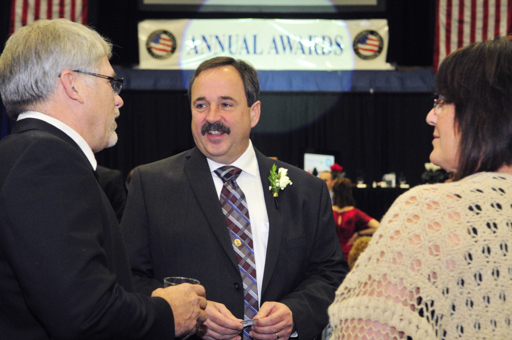 Business person of the Year award winner Gary Peachey, center chats with John Babb, left and Linda Babb, before the Kennebec Valley Chamber of Commerce annual awards on Friday January 23, 2015 at the Augusta Civic Center.