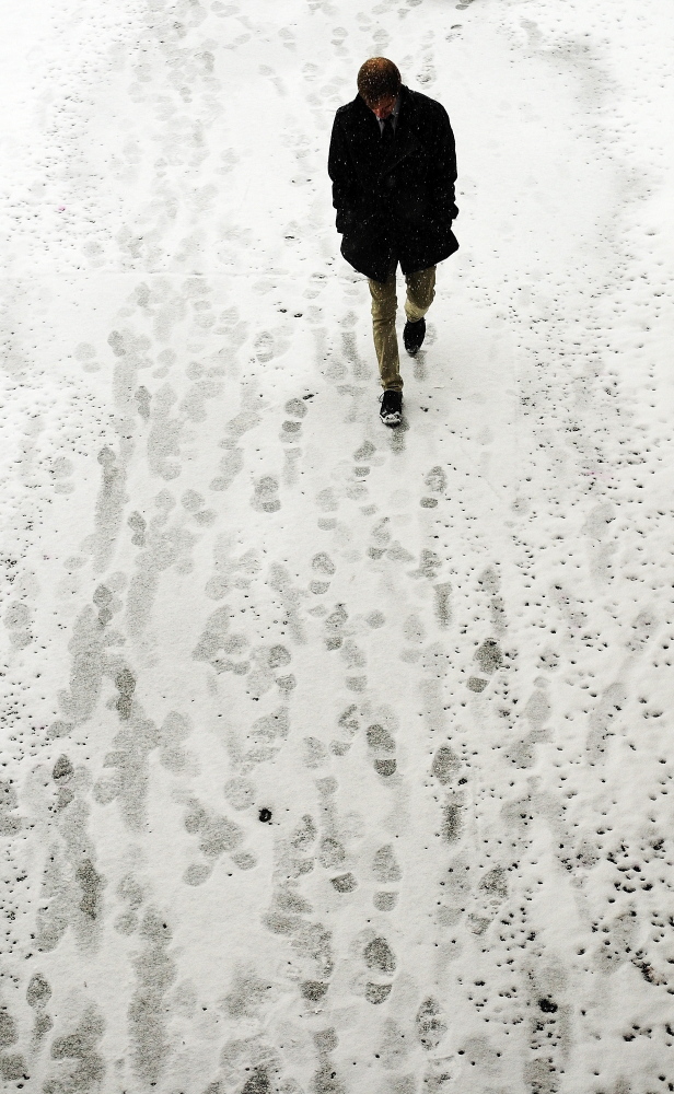 A man walks out of the snow and into the Augusta Civic Center on Saturday as a snowstorm begins around 2 p.m. in Augusta.