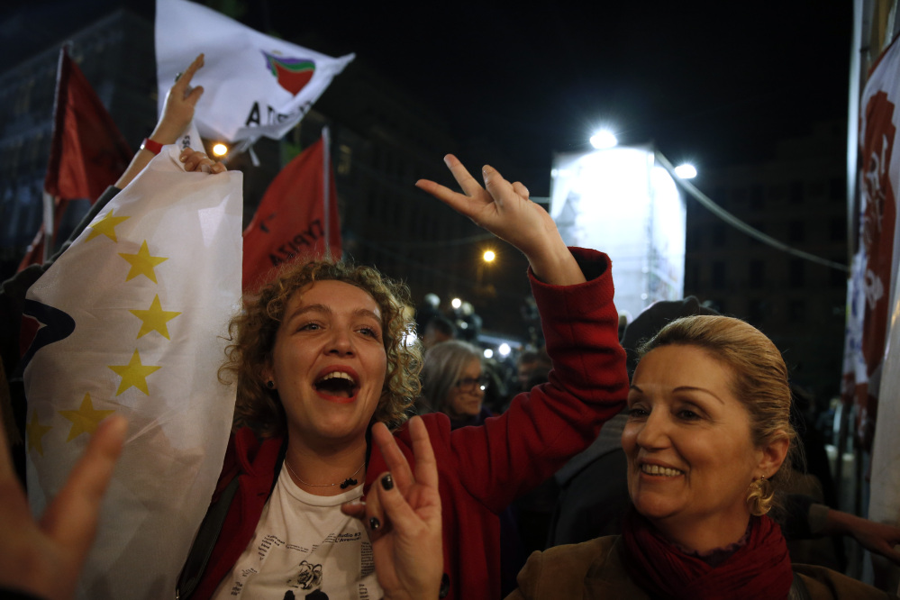 Supporters of left-wing Syriza party react after exit poll results in Athens, on Sunday. The anti-bailout Syriza party won a decisive victory in Greece’s national elections, according to projections by state-run TV’s exit poll, in a historic first for a radical left-wing party in Greece.