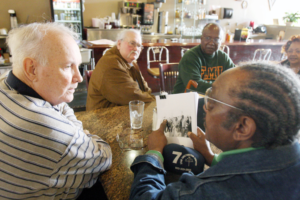 In this Jan. 23, 2009, file photo, Elwin Wilson, left, and Friendship 9 member Willie McCleod, right, look over pictures from civil rights incidents in Rock Hill, S.C., in the 1960s.