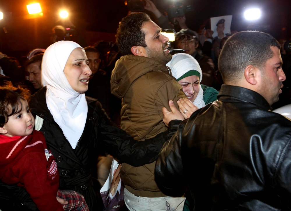 A man comforts the wife, right, of a Jordanian pilot, Lt. Muath al-Kaseasbeh, who is held by the Islamic State group militants, during a protest in front of the Royal Palace in Amman, Jordan, on Wednesday.