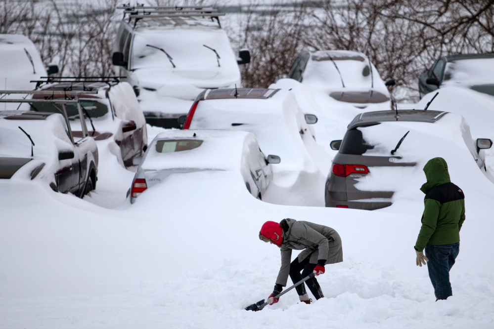 Portlanders dig their cars out at the Eastern Prom on Wednesday. During winter storms, city officials urge residents to keep their vehicles off snow-clogged streets.