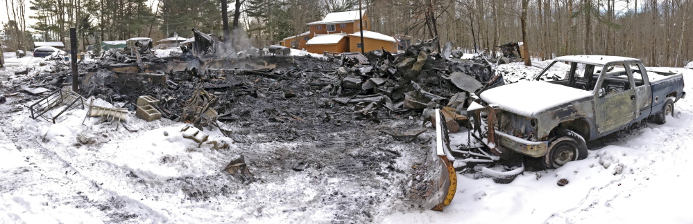 Steam rises from the remains of a house on Wednesday at 452 Mills Road in Whitefield. The house was destroyed by fire during the snow storm on Tuesday afternoon but firefighters from several departments stopped it from spreading to Michael Farrell’s home, in background, about 50 feet away.