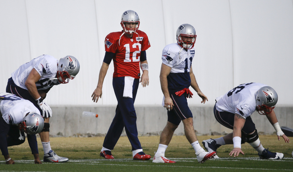 New England Patriots quarterback Tom Brady (12) warms up with teammates, including wide receiver Julian Edelman (11), during practice Wednesday in Tempe, Ariz. The Patriots play the Seattle Seahawks in Super Bowl XLIX Sunday in Glendale, Ariz.