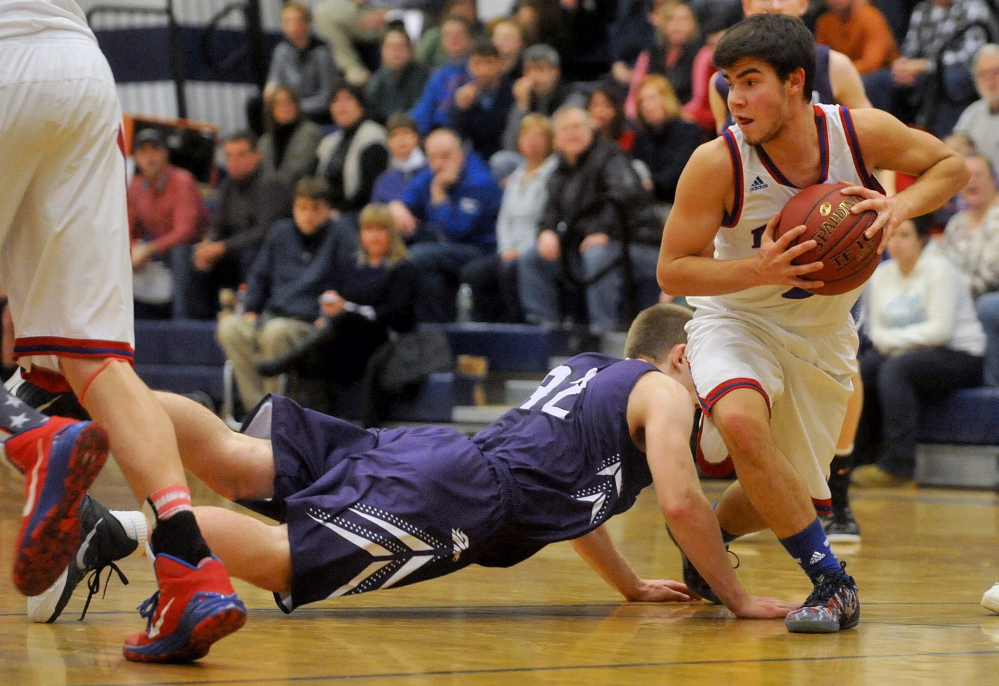 Messalonskee High School’s Noah Caret (2) grabs the loose ball as Hampden Academy’s Conary Moore (32) dives for it in the first half Wednesday in Oakland.