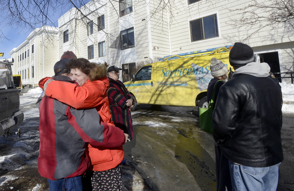 Ellen Schlehuber gets a hug from fellow tenant Jeff Buotte as residents are allowed to retrieve personal items Thursday after an early morning fire at Centennial Place apartments in Old Orchard Beach. The fire, which was blamed on a cooking accident, displaced two dozen elderly and disabled people.