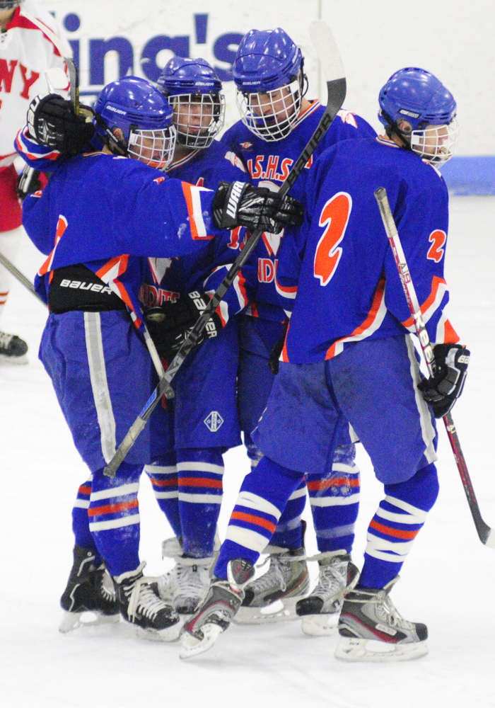 Members of the Lawrence/Skowhegan hockey team celebrate after Cody Martin scored to snap a 1-1 tie in an Eastern A game Thursday at the Bank of Maine Ice Vault in Hallowell.