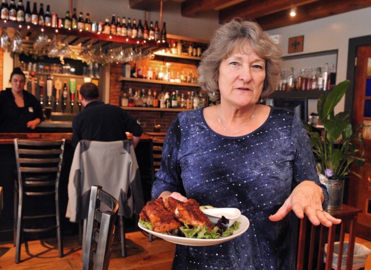 Owner Coby Thibeau talks about her beer can chicken wings Saturday at The Maine House in Hallowell. She said the business would go through about 100 pounds of wings during its Super Bowl party.