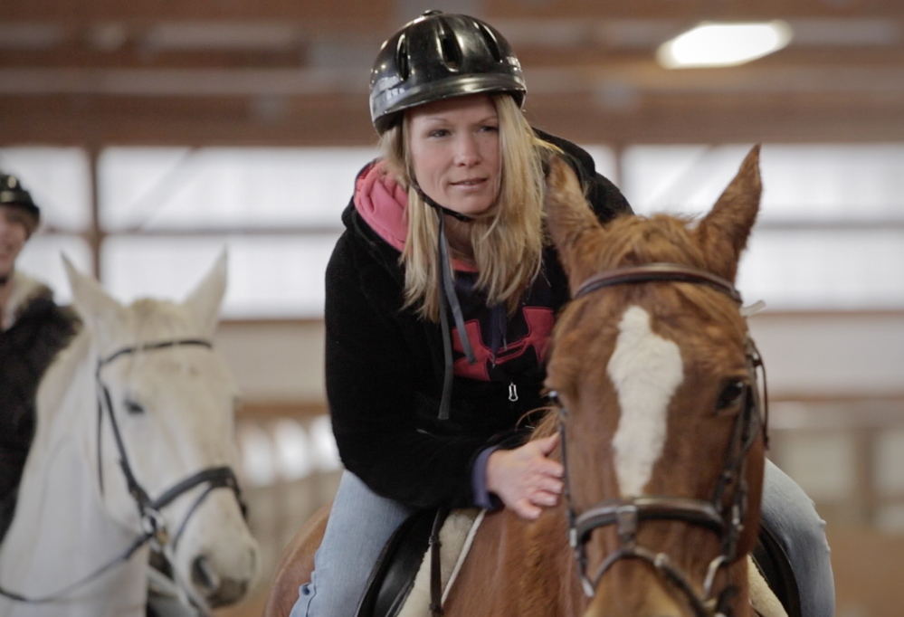 Heather Fields, an inmate at the Southern Maine Re-entry Center, rides a horse at Carlisle Academy. Riding has shown her that there are things other than drugs “that fill you up,” she said.