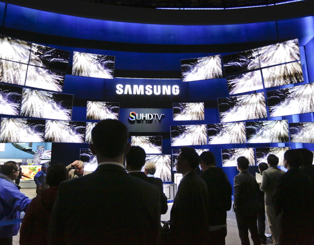 The Samsung booth draws a crowd Tuesday at the gadget show in Las Vegas. Some of the company's new sets make colors purer and the screen brighter. The Associated Press