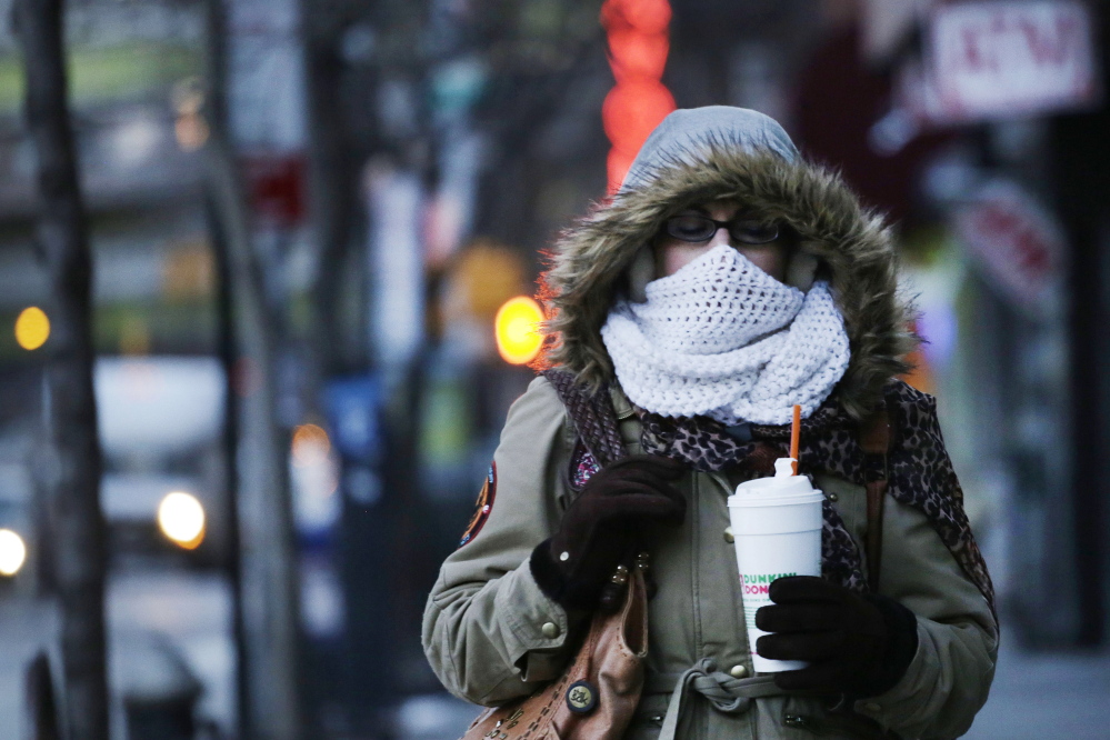 A woman carries a beverage in a plastic foam cup, Thursday, Jan. 8, 2015 in New York. Nearly two years after former Mayor Michael Bloomberg suggested banning foam food containers, Mayor Bill de Blasio is expected to announce the ban is a reality. (AP Photo/Mark Lennihan)
