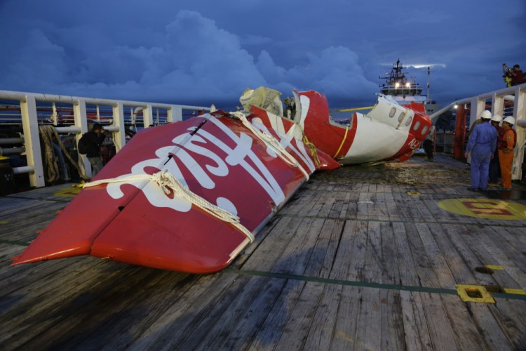 Parts of AirAsia Flight 8501 is seen on the deck of rescue ship Crest Onyx at Kumai port in Pangkalan Bun, Indonesia, on Sunday. A day after the tail of the crashed AirAsia plane was fished out of the Java Sea, the search for the missing black boxes intensified Sunday with more pings heard. The Associated Press