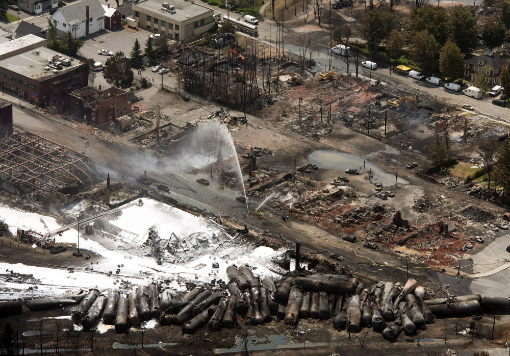 The downtown core is in ruins as firefighters water smoldering rubble in Lac-Megantic, Quebec, after a train derailed, igniting tanker cars carrying crude oil. 2013 Associated Press File Photo