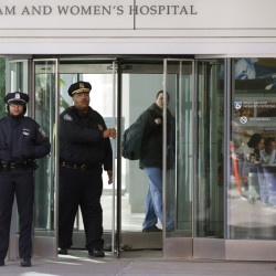 Boston Police Superintendent-in-Chief William Gross, center left, walks through a revolving door as he departs the Shapiro building at Brigham and Women’s Hospital on Tuesday in Boston. The Associated Press