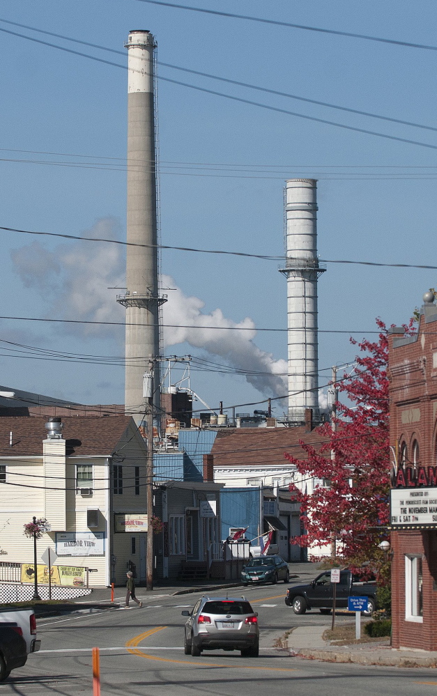 Smokestacks at Verso Paper’s mill loom over the town of Bucksport last fall. More than 500 jobs were eliminated when the mill closed in December. 2014 Press Herald file/Kevin Bennett