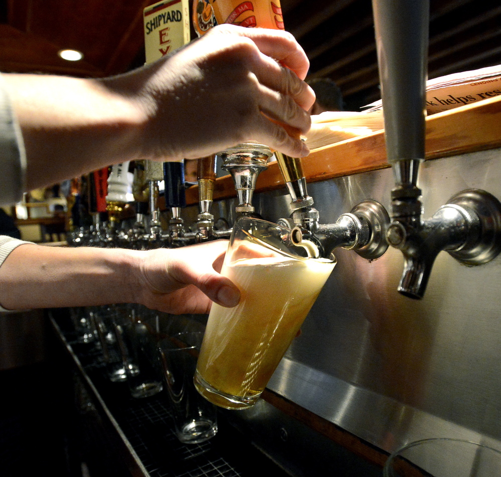 Bartender Melissa Cyr pours a pint at 3 Dollar Dewey’s in Portland. A legislator is proposing a statewide law requiring that pints are poured at a full 16 ounces. John Patriquin/Staff Photographer