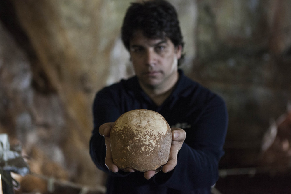 Dr. Omry Barzilai of Israel’s Antiquities Authority holds an ancient skull found in a cave near the northern city of Nahariya. The skull dates from around 55,000 years ago. The Associated Press