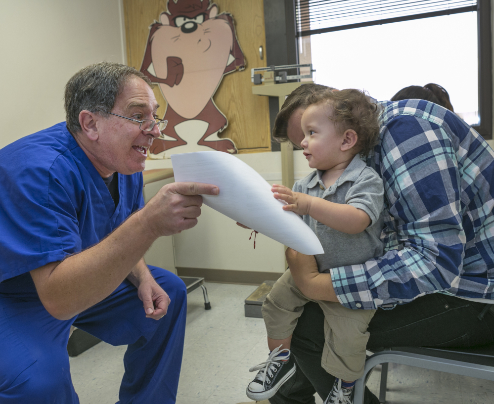 Pediatrician Charles Goodman talks with Carmen Lopez and her 18-month-old son Daniel after he was vaccinated at Goodman’s practice in Northridge, Calif., Thursday. The Associated Press